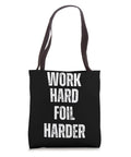 Black Work Hard Foil Harder Wing Foil Tote Bag For Wing Surfing Fans And Wingboarding Coaches with dark straps.