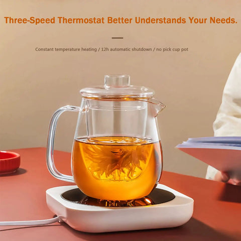 Smart Desk Electric Coffee Mug Warmer With Three Adjustable Heat Settings And Twelve Hour Auto Shut Off featuring a glass tea pot on a white base.