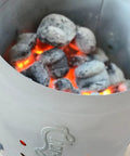 Chimney Style Charcoal Grill Starter with Quick Release Trigger for fast coals lighting, featuring glowing coals inside.