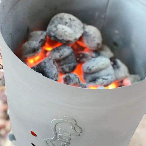 Chimney Style Charcoal Grill Starter with Quick Release Trigger for fast coals lighting, featuring glowing coals inside.