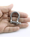 Badass Heavy Duty Bow Shape Screw Pin Anchor Shackle One Quarter Inch 304 Stainless Steel Four Pack in hand, showcasing size.