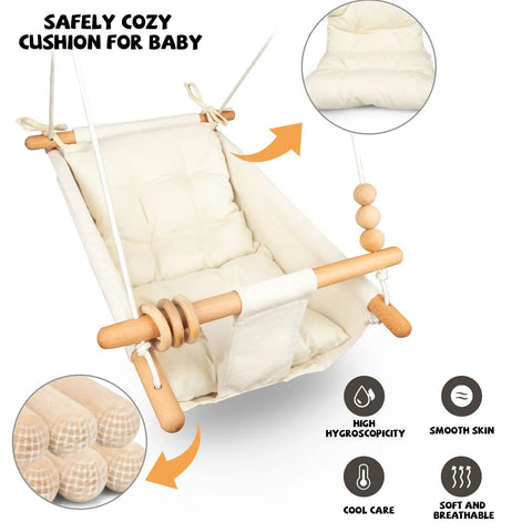Cream-colored baby swing with cushion, wooden handles, and adjustable ropes for indoor and outdoor use with 5-point safety belt.