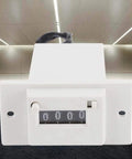 Four Digit Mechanical Pulse Counter Totalizer, Electromagnetic Industrial Counter, DC12V Powered for Water Meter Systems, Electricity Monitoring, Production Line Automation, A Go To Workhorse for High Accuracy and Fast Counting, white plastic front view