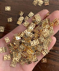 Hand holding 100 Piece Set Tiny Metal Mini Hinges With Screws For Dollhouse Furniture Cabinets Closets And Miniature Boxes Retro Style For Diy Craft Projects And Small Home Decor.