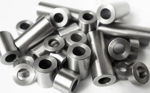 Close-up of steel spacers; round, unthreaded bushings, 1 in OD x 1/2 in ID, 5-pack.