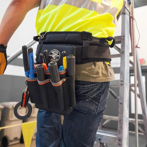 Tradesman Pro Tool Pouch With Tape Thong And Heavy Duty Reinforced Bottoms, attached to belt, holding tools on worker's side