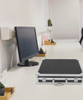 Slick Aluminum Alloy Toolbox Briefcase With Heavy Duty Hard Shell Design On Desk Next To Monitor And Plants