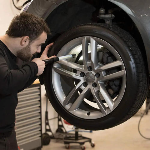 Person using Rechargeable Inspection LED Work Light With Top Spotlight 600 Lumen on car tire for inspection in garage