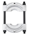 Bearing puller clamp with silver aluminum housing and black guide rods for wheel hub removal