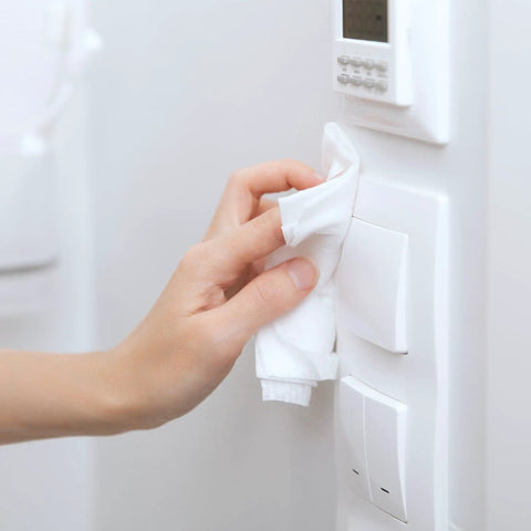 Premium 96 Percent Isopropyl Alcohol Wipes Bulk Pack Comes Packed With 1000 Lint Free SMS Cloth sanitizing a light switch.