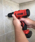 Gunpla cordless drill, red and black, with bit, drilling into tiled wall