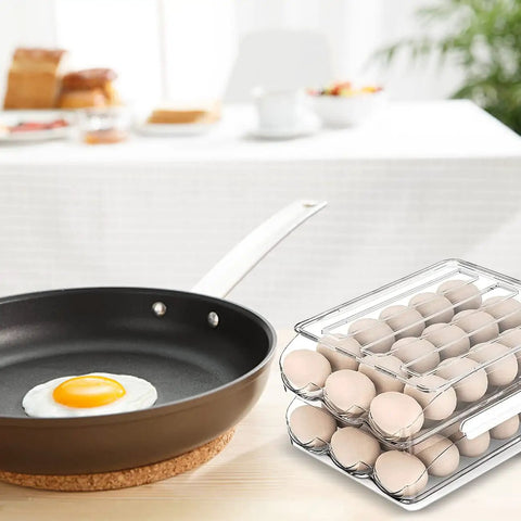 Auto Rolling Egg Storage Bin For Refrigerator, 36 Egg Capacity, Clear Plastic Two Layer Stackable Organizer With 7 Degree Slope beside a frying pan