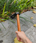 Person holding Multi Function Garden Hoe Tool With Long Wooden Handle For Weeding And Soil Loosening