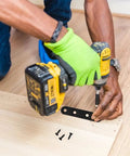Person installing a 12 Piece Premium Steel Heavy Duty Black Straight Corner Braces With Matching Screws on wood surface.