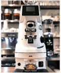 Precision Automatic Coffee Tamper Featuring Smooth Adjustable Pressure And Customizable Tamping Profiles For 54 Millimeter Portafilters with a sleek white design.