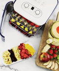 Countertop Food Dehydrator With Four Trays For Whipping Up Dried Fruit Veggie Chips And Snack Batches showing trays with fruits.