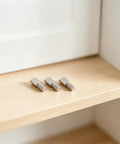 Close-up of 80 Pack 5mm Shelf Pegs Spoon Shape Iron Cabinet Pegs, Heavy Duty Nickel Plated Bracket on wooden shelf