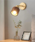 Walnut Wood Wall Sconce With Brass Arm Rotatable Head And Adjustable Cylinder Shade, mid-century modern lamp beside bed and vase