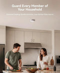Hassle Free Smoke Detector Designed With Adaptive Sensing To Slash Nuisance Alerts While Delivering Dependable Household Fire Protection Runs Smooth On A Single Nine Volt Battery Offers Quick Easy Wall Install mounted on kitchen ceiling above couple preparing food.