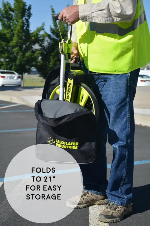Person holding DigiRoller Plus III 12.5 Inch Electronic Distance Measuring Wheel with backlit display in carrying pack outdoors.