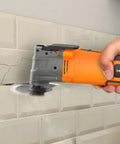 Using Beast Oscillating Multitool Kit 4.2 Amp With 5 Degree Oscillation on tile for demolition, showing auxiliary handle.