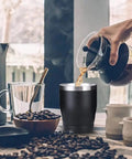 Built Tough 304 Stainless Steel Insulated Travel Mug keeping your morning grind fresh, filled with hot coffee, on a table with coffee beans.