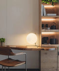 Mid Century Modern Brass Table Lamp With Gold Glass Globe on wooden desk in modern home office setting