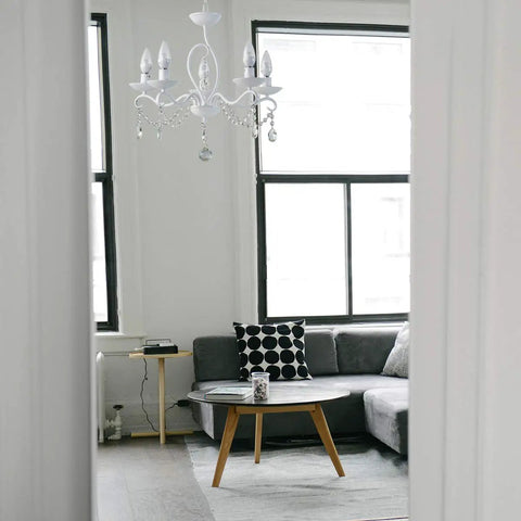 French Country Crystal Pendant Light With White K9 Crystals And Wrought Iron Frame E12 Candle Style in a living room.