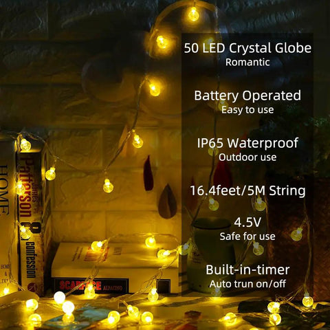 Battery Operated Globe String Lights With 50 LED Crystal Orbs 16.4 Ft Waterproof Fairy Lights glowing on wall and books