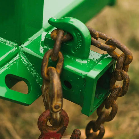 Green tractor hitch with chain, part of Dual Design Gooseneck Tractor Trailer Hitch With Hay Bale Spear Charcoal Frame Two Inch Receiver Mount