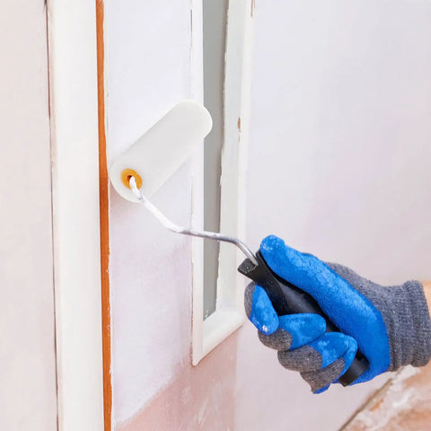 Hand holding a mini roller with a white sponge cover painting a wall, demonstrating the Ten Pack Of White Sponge Paint Roller Covers For Walls And Ceilings No Drama Mini Size Slick Operation Great For Diy Renos Quick Change Design Smooth Operator Finish Every Time.