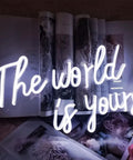 World Is Yours White LED Neon Sign For Bedroom Decor Bar Party And Cafe Vibe, USB Powered 17x11 Inches against magazine backdrop