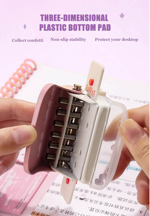 Hands holding Six Hole Puncher For A4 A5 B5 Loose Leaf Notebooks And Scrapbooks, showing compact design and plastic bottom pad.