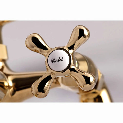 Close-up of polished brass cross handle labeled 'Cold' on Charleston Deck Mount Clawfoot Tub Filler With Hand Shower Six And A Half Inch Centerset