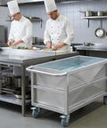 Heavy Duty Commercial Food Prep Cart With Slick Rolling Locking Casters Featuring Deep 304 Stainless Steel Soak Tank in a busy kitchen.