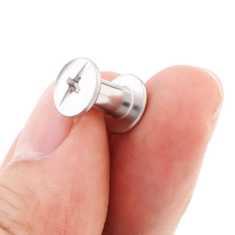 Fifty Pack Chicago Screws And Leather Rivets Featuring Phillips Cross Head Drive held in hand, stainless steel fastener for crafts.