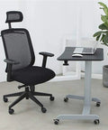 Height Adjustable Mobile Standing Desk With Smooth Roll Wheels Built Tough Rust Resistant Steel Laptop Lectern Workstation Spacious Matte Black Surface No Extra Fluff Office Or Home Setup beside an ergonomic black office chair.