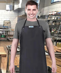 Person wearing Pro Grade Heavy Duty Vinyl Apron Big Ol Extra Large 43 By 29 Inch Chest To Knee Coverage Waterproof in kitchen.