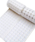 Front view of self-adhesive white circular dots on a sheet, 0.59-inch diameter, with a roll of dots in the background.