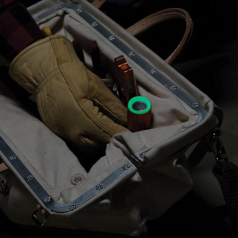 Worker placing a Rechargeable LED Flashlight With Flood Light 500 Lumens USB C Rechargeable Magnetic End Cap in a tool bag