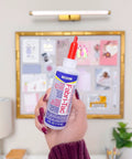 Person holding Fabri-Tac Premium Fabric Glue Quick-Drying Crystal Clear Permanent Bond For Fabrics Canvas Lace Wood And More 4-Ounce