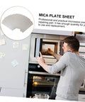 Man installing six piece microwave waveguide mica sheet set for heat insulation and fire retardant covers in microwave oven