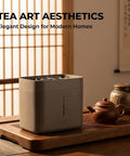 Automatic Desktop Cup Washer With 1.8L Tank Electric Glass Rinser on a wooden table next to a tea set.