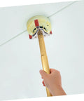 Dead Simple Fire Alarm Removal Tool With Long Extendable Pole in use detaching a ceiling smoke sensor.