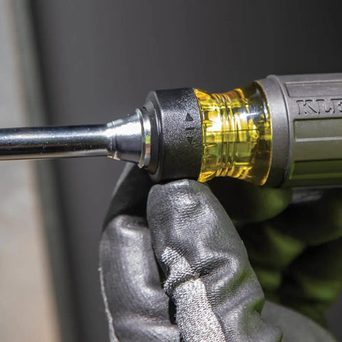 Close-up of a Ratcheting Multi-Bit Screwdriver 15-In-1 with gloved hand adjusting the ratchet mechanism and visible handle.