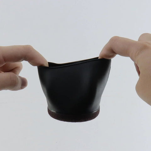 Smooth Rolling Tpe Caster Cups For Office Chairs Straight Up Floor Protectors That Block Hardwood And Carpet From Deep Scrapes Quiet Slide Wheel Stops Five Pack Durable Rubber Foot Caps shown being held, flexible black TPE material.
