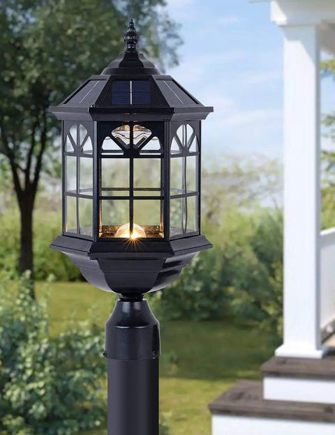 Solar Post Light Fixture For Outdoor Gardens And Patios With Vintage Die Cast Aluminum In Oil Rubbed Black And Clear Glass, Weather Resistant Pier Lamp, LED Warm White Or Cool White, No Fuss Install And Hardwired Ready against a garden background.