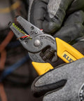 Person using compact lightweight wire stripper and cutter for stranded and solid wires, yellow handles, precision ground jaws visible.