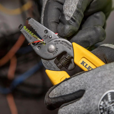 Person using compact lightweight wire stripper and cutter for stranded and solid wires, yellow handles, precision ground jaws visible.