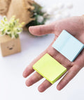 Hand holding Mini Sticky Notes One Point Five By Two Inches Bright Colors Self Stick Pads 24 Pads Per Pack 75 Sheets Per Pad